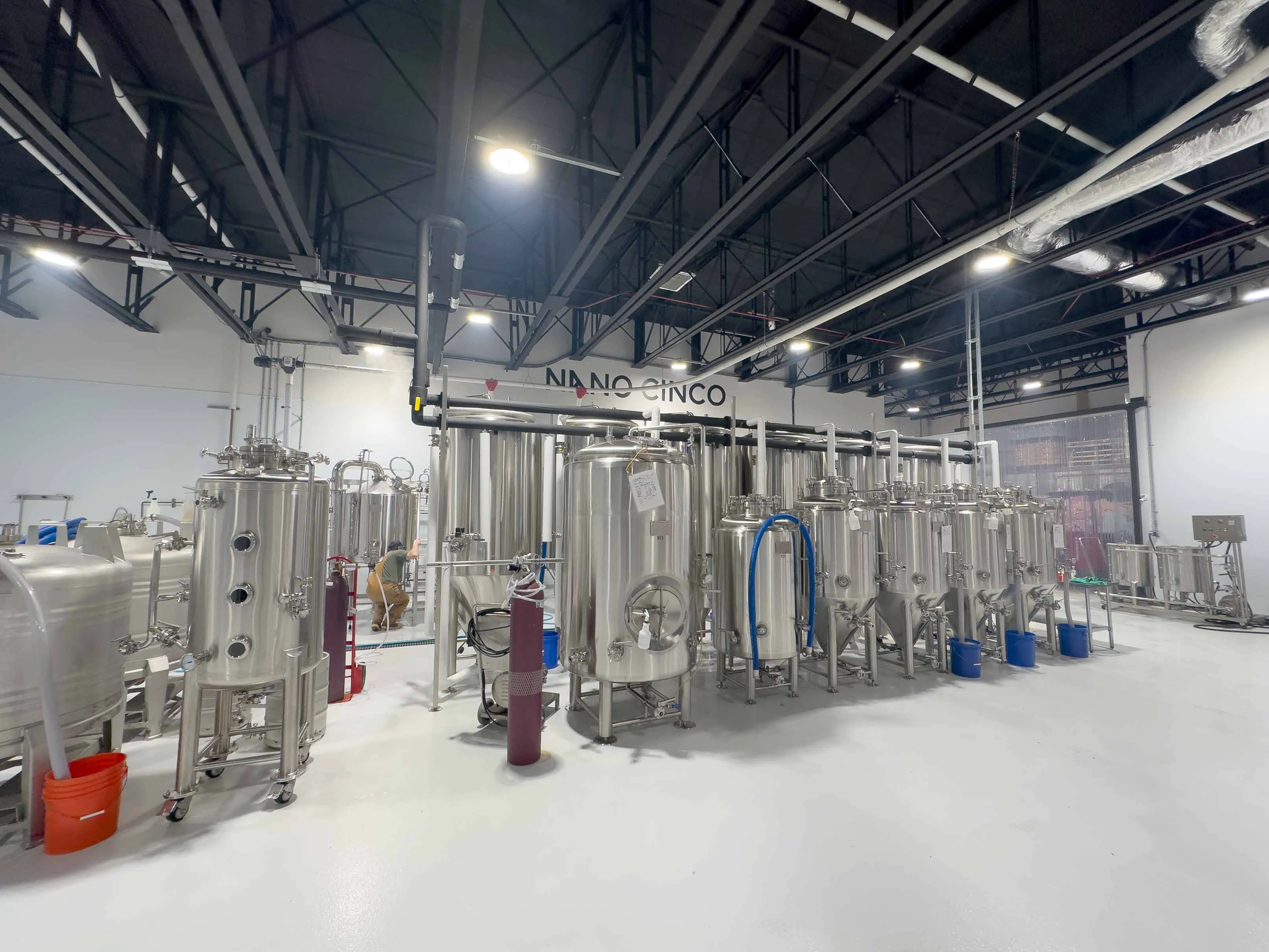 Brewer operating 3BBL pilot brewing system at Brasserie Artisanale